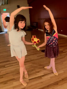 Two dancers holding a flower